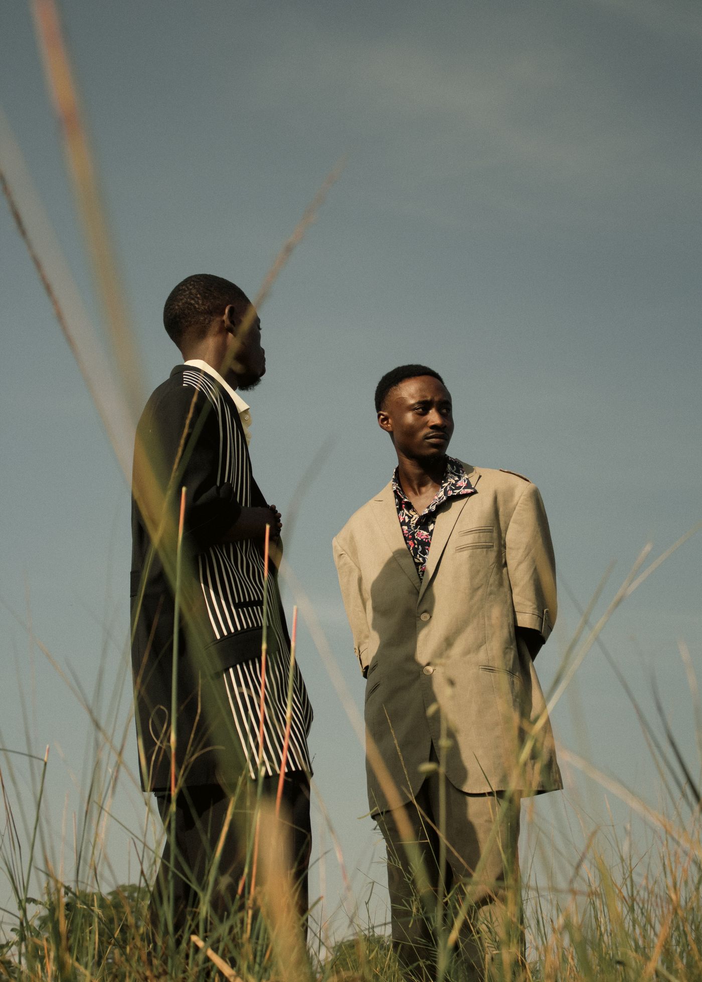 Two men in suits standing in a field