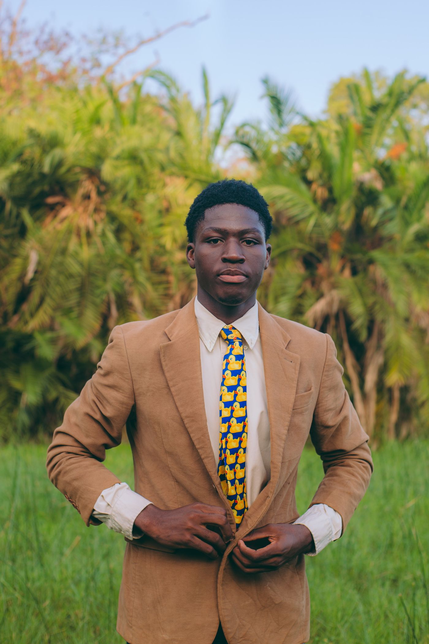 A young man in a suit outdoors in Ghana